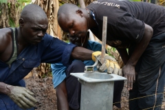 Greater-Cincinnati-Pros-Water-Buseesa-Uganda-March-2015-Matia-and-Cosmos-work-together-to-install-the-base-of-a-hand-pump